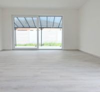 Spacious bright interior with wood-patterned flooring of a family house.