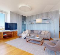 Living room with a large window, sofa, and television, floor with wooden decor.