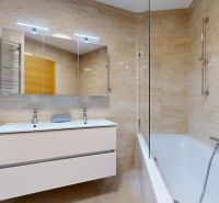 A bathroom with stylish tiles and a bathtub in a 4-room apartment.