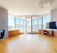 Spacious living area in a 4-room apartment with wood-patterned flooring and a view.