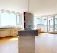 A kitchen with large windows and a wooden decor floor in a 4-room apartment.