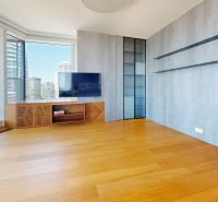 Living room with glass doors, wood-patterned flooring, and a view in a 4-room apartment.