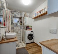 A bathroom in a family house with wooden floor decor and a shower.