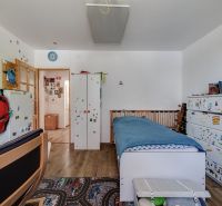 Children's room with a bed, shelves, and a wooden floor decor in a family house.