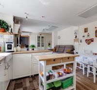 Kitchen and dining area with a sofa in a family house. Floor with wooden decor.