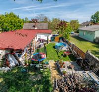 A family house in Potzneusiedl with a yard, trampoline, swimming pool, swing, and garden furniture.