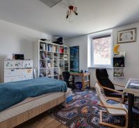 A children's room in a family house with a decorative carpet and shelves for toys.