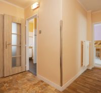 Entrance hallway in a 2-room apartment with a wooden decor floor and tiles.