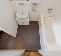 Bathroom in a 2-room apartment with tiles and a bathtub.