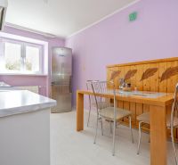 A kitchen in a 2-room apartment with purple walls and a dining table.