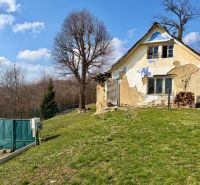 An older house on a plot in Lubina surrounded by nature and trees.
