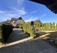 An airy exterior in Stará Lesná with a driveway surrounded by greenery and family houses.