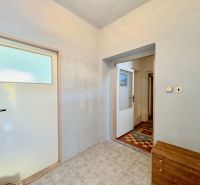 In the family house, there are two white doors, gray walls, and tiles.