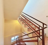 A staircase with a brown railing in a family house.