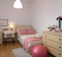 A room in a 4-room apartment with a bed, dresser, desk, and decorations.