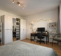 Bedroom with a desk, wardrobes with wooden decor in a 4-room apartment.