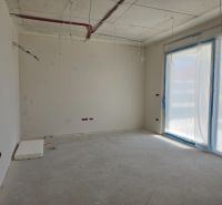 Unfinished interior of a 3-room apartment with a plastic window and raw flooring.