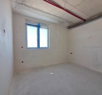 An empty room in a 3-room apartment with a concrete floor and a window.