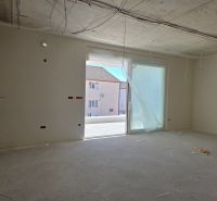 A vacant space in a 3-room apartment with an opening to the balcony and unfinished electrical installations.