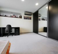 A spacious room with a desk and a large built-in wardrobe in a family house.