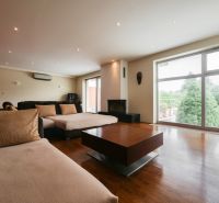 Living room in a family house with a large window and a wooden decor floor.