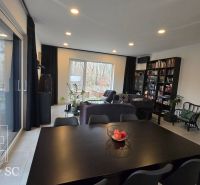 Living room in a family house with spacious windows and comfortable seating.
