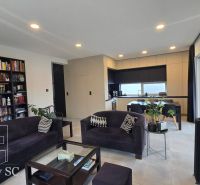 Living room with a library and kitchen in a family house, floor with wooden decor.