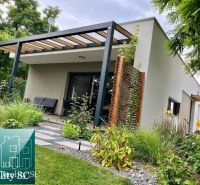 A family house in Senec with a garden and a covered terrace surrounded by greenery.