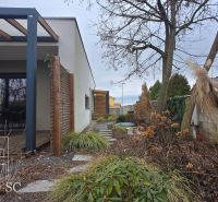 A family house in Senec with a terrace, wooden pergola, and landscaped garden.