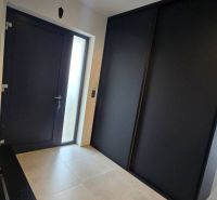 Entrance hallway in a family house with dark doors and a large wardrobe.