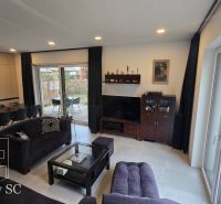 Living room in a family house with a sofa, dining table, and a view of the terrace.