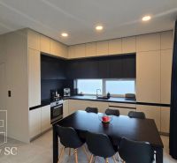 A kitchen in a family house with an elegant kitchen unit and a dining table with chairs.