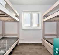 Bunk beds in a cabin with a wooden floor decor and a window with blinds.