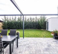 In the exterior of the family house at Slnečné jazerá juh in Senec, there is a terrace and a garden.