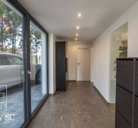 Interior of a family house with a glass corridor and a view of the parking lot.