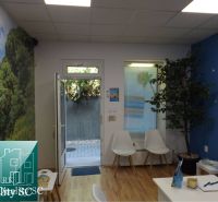 Interior of a family house with a blue wall, white chairs, and a wooden decor floor.