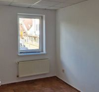 White wall with a window, radiator, and tiles in a family house.