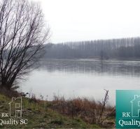 River with a misty background and bank near the Old Gabčíkovo Harbor. Land - residential.