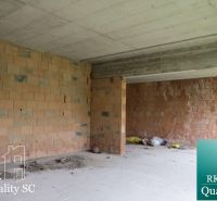 An unfinished interior of a family house with unplastered brick walls.