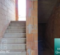 Staircase and brick walls inside a family house under construction.