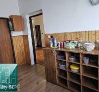 A kitchen with wooden decor in a family house with a pantry and storage spaces.