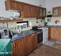 A kitchen in a family house with wooden cabinets and a floor with a wooden decor.