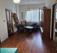 Interior of a family house with armchairs, a table, and a floor with a wood decor.