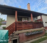 A family house in the village of Tureň with wooden railings and floral decorations on the porch.