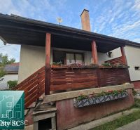 The family house on the street in Turna has a wooden balcony with floral decorations.