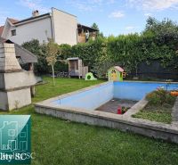 The garden of a family house in Tureň with a gazebo, a swimming pool, and a children's playhouse.
