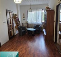 Interior of a family house with a wooden decor floor, armchairs, and a coffee table.