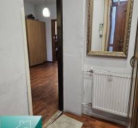 Interior of a family house with a wooden decor floor, mirror, and radiator.