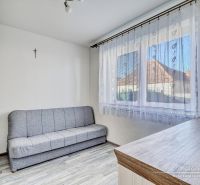 A sofa and cabinets in a room of a family house, with a wooden decor floor.