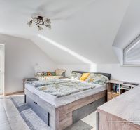A bright attic bedroom with a comfortable bed and a view, family house.